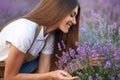 Smiling woman smelling scent in lavender field.