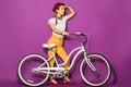 side view of stylish asian girl standing with bike and looking away Royalty Free Stock Photo