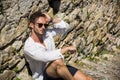 Relaxing stylish man sitting on stone stairs