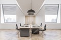 Side view on stylish work places in spacious sunlit office with parquet, wooden tables and wall decoration and city view from