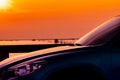 Side view of SUV car with sport and modern design parked on concrete road by the sea at sunset. Hybrid and electric car technology Royalty Free Stock Photo