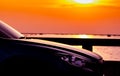 Side view of SUV car with sport and modern design parked on concrete road by sea beach at sunset. Hybrid and electric car Royalty Free Stock Photo