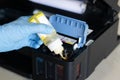 Side view of technician filling printer with ink Royalty Free Stock Photo