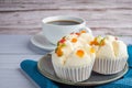 Side view of Thai steamed cupcakes topped with dry fruit on a plate on a blue cloth with a white coffee cup background. Khanom pui Royalty Free Stock Photo