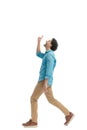 side view of thankful young man pointing finger to the sky and smiling Royalty Free Stock Photo