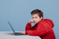 Side view of thoughtful schoolboy in red sweatshirt Royalty Free Stock Photo