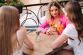 Side view of three beautiful women celebrating event in cafe. Females drinks alcoholic cocktails and have fun Royalty Free Stock Photo