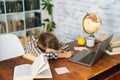 Side view of tired little child school girl sleeping at work desk lying on notebooks, exhausted child schoolgirl feeling