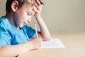 Side view to cute boy doing his homework. Royalty Free Stock Photo