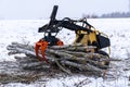 Small stand-on mini skid steer with grapple full of wooden logs Royalty Free Stock Photo