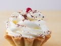 Side view to the one sweet cupcake - cream and condensed milk on light background.