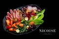 Side view of traditional French Nicoise salad with roasted tuna potato, tomato, lettuce, olives and quail eggs served on platter Royalty Free Stock Photo
