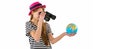 Side view of Trendy young girl in striped t-shirt and red hat looking through binoculars to world globe in her hands Royalty Free Stock Photo