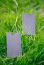 Side view of two black price tags for clothing creative layout of lawn green grass with logo tag Royalty Free Stock Photo