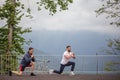 Side view of two caucasian sportsmen doing lunges in mountains. Royalty Free Stock Photo