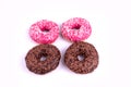 Four freshly baked delicious donuts with sprinkles laying on white background