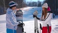 Side view two confident women discussing advantages and disadvantages of different winter sports. Beautiful slim young