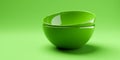 Side view of two stacked empty green ceramic bowls or dishes on green background