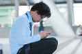 Side view of unemployed stressed young Asian man looking mobile smart phone for find job. Unemployment concept. Royalty Free Stock Photo