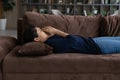 Side view unhappy Indian woman lying on couch alone