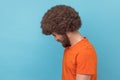 Side view of unhappy man with Afro hairstyle looking at camera with sad facial expression. Royalty Free Stock Photo
