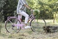 Side view of unrecognizable young hipster man on a pink vintage bike with natural enviroment Royalty Free Stock Photo