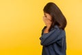 Side view of upset dramatic girl in denim shirt crying with sorrow, wiping tears, feeling lonely hopeless Royalty Free Stock Photo