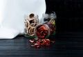 side view of various dried fruit slices in glass jars strawberry banana and kiwi on black background with copy space