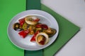 Side view of vegetarian dish. Mix of Grilled vegetables on gray plate. Colorful green background. Royalty Free Stock Photo
