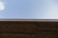 Side view of very old wooden barn with rusty roof, a little blue sky at the top. Royalty Free Stock Photo