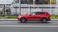 Side view of Volvo XC60 second generation T5 AWD suv in motion. Red pre-facelift styling CUV car moving on the street