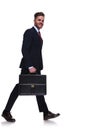 Side view of walking businessman with suitcase in hand Royalty Free Stock Photo