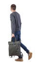 Side view of walking man with green bag. backside view of person