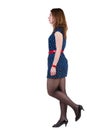 Side view of walking woman in blue dress Royalty Free Stock Photo