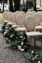 Side view of the wedding decor are chairs in the woods decorated with green candlesticks and flowers. Wedding day