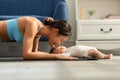 Side view of Wellness Asian woman mom doing plank exercise and kissing her baby at cozy home.Happy healthy mother yoga plank with Royalty Free Stock Photo