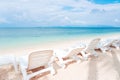 Side view of white beach chairs on white sand tropical beach wit Royalty Free Stock Photo