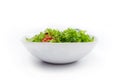 Side view of white bowl with vegetables isolated on white background. Green salad, dill, tomato