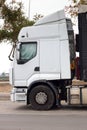 Side view of the white cab of a European truck parked in an industrial estate