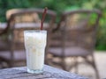 Side view of white chocolate cold in the glass on wooden table