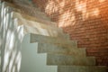 Side view of white empty stairs with brown brick wall background.