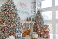 Side view of white living room with big windows and Christmas New year decor,light garland and Christmas tree with presents under Royalty Free Stock Photo