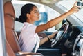 Side view of woman adjusting rear view mirror