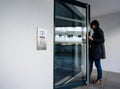 Side view of woman entering apartment building intercom access Royalty Free Stock Photo