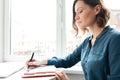 Side view of a woman making notes in her diary Royalty Free Stock Photo