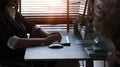 A woman office worker working with computer and sitting by the window in office.