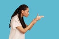 Side view of woman pointing finger gun, aiming and threatening to shoot with pistol hand gesture. Royalty Free Stock Photo