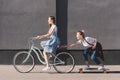 side view of woman riding bicycle and towing her smiling female friend