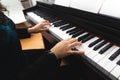 Side view of woman& x27;s hands playing piano by reading sheet music. Selective focus Royalty Free Stock Photo