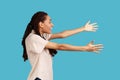 Side view of woman stretches hands and looks directly at camera, gives hug to you, I want to embrace Royalty Free Stock Photo